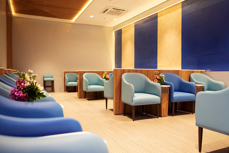 A room with blue chairs and a blue wall Description automatically generated