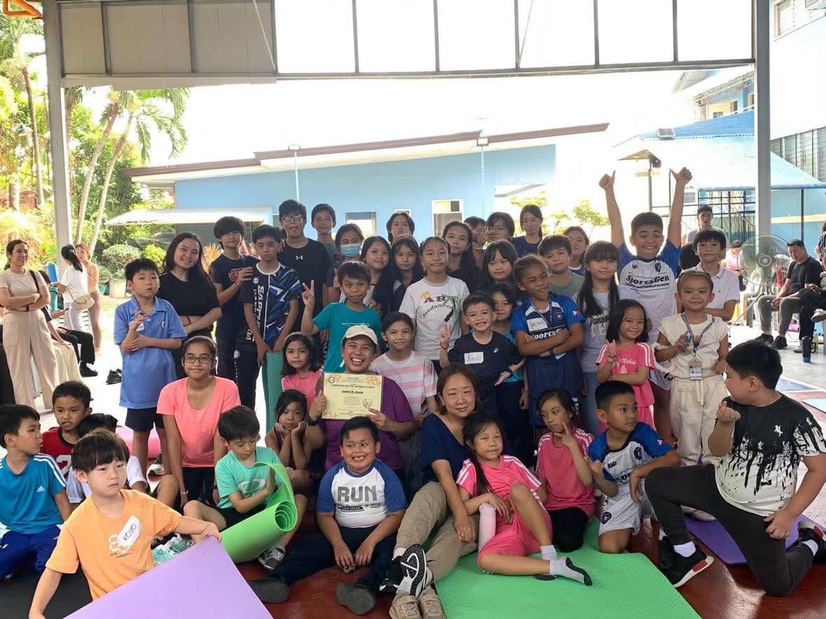 5 - Teacher Janice taking the photo opportunity after her yoga session with the students and their parents